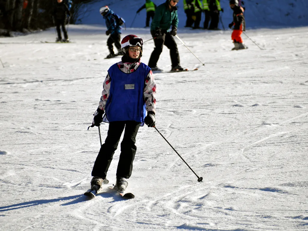 Skifahrerin steht mit Skibrille auf der Piste.